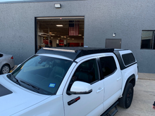 Load image into Gallery viewer, Front right view of Economy Roof rack on a white Toyota Tacoma - Cali Raised LED