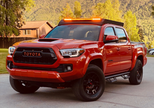 Load image into Gallery viewer, Front view of Economy Roof Rack with amber light baron a red Toyota Tacoma - Cali Raised LED