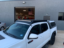 Load image into Gallery viewer, Front right view of Economy Roof rack on a white Toyota Tacoma - Cali Raised LED
